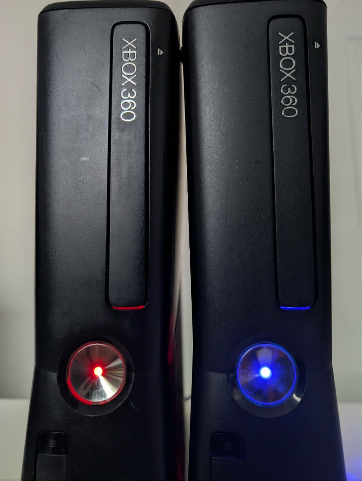 Close-up of modded Xbox 360 power buttons with red and blue LED rings